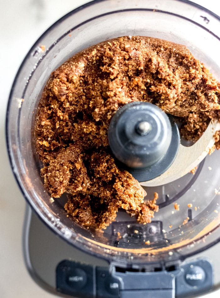 Overhead image of energy ball dough in a food processor container.