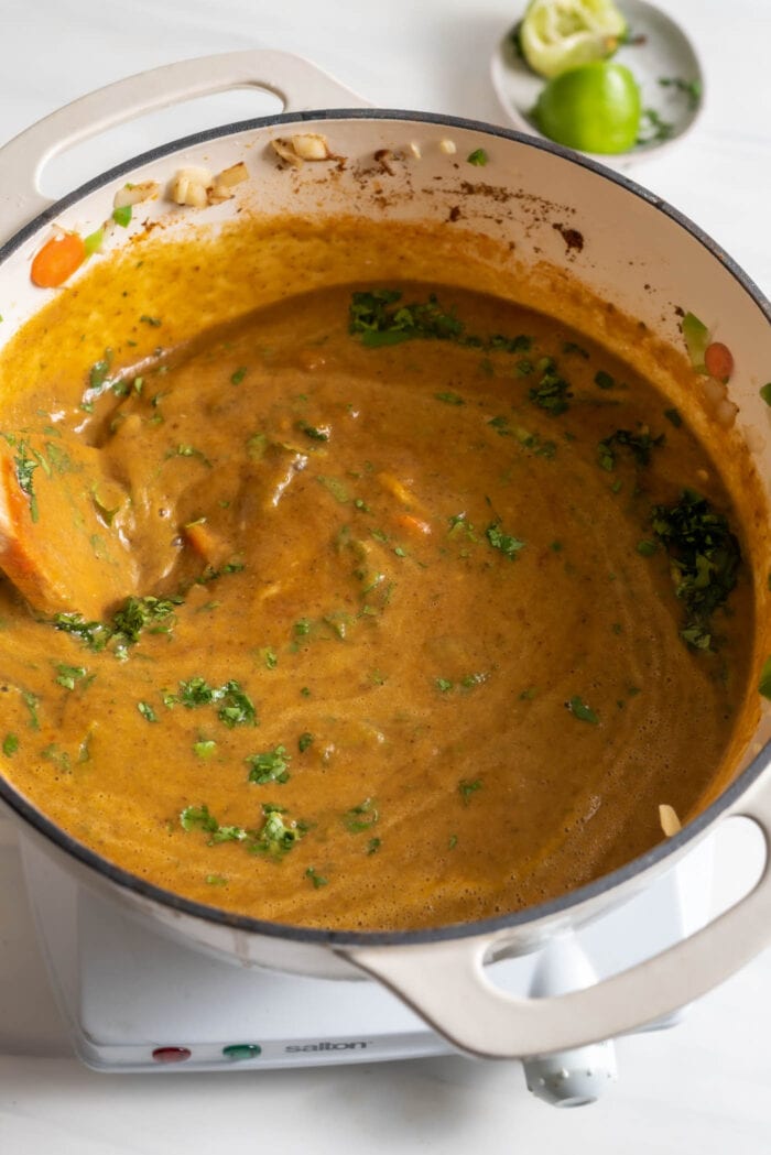 Stirring cilantro and lime into a pot of black bean soup.