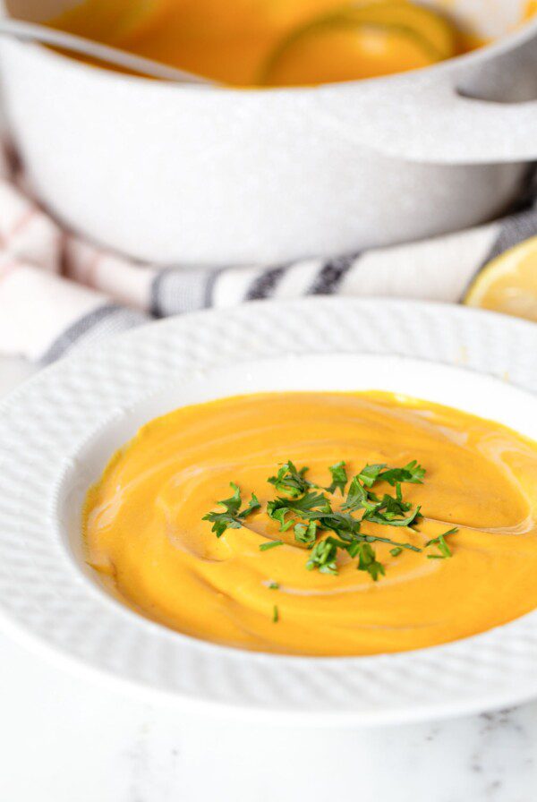 Bowl of creamy soup topped with parsley.
