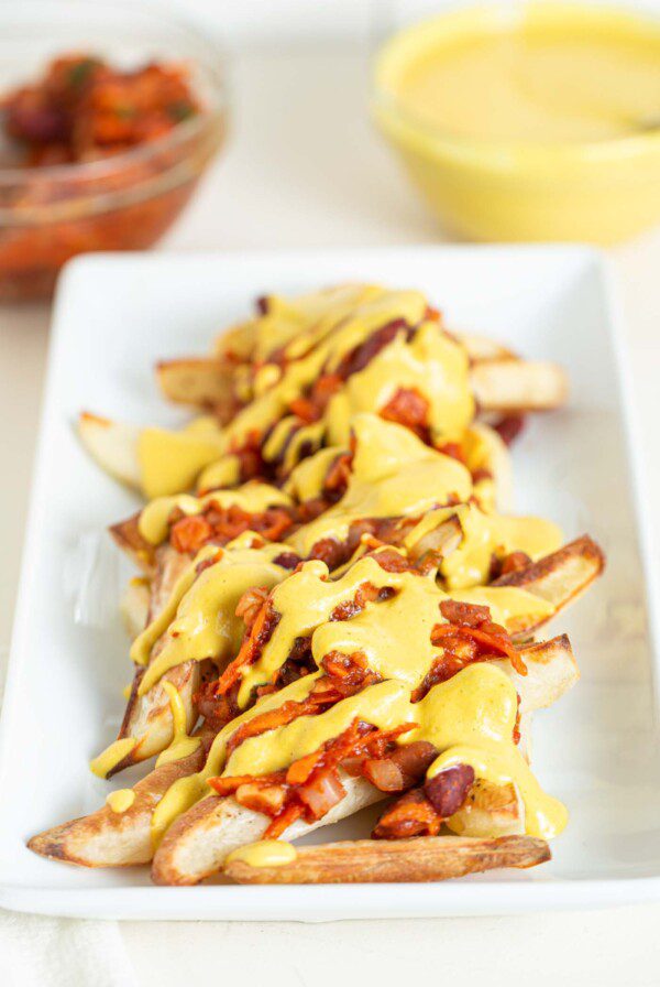 A plate of baked fries topped with chili and cheese sauce.