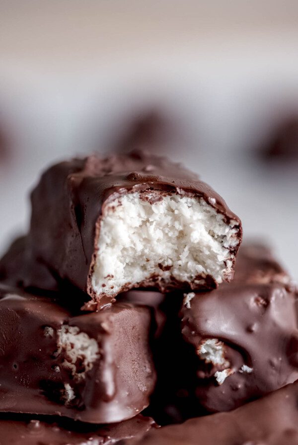 A homemade Mounds candy bar with a bite taken from it so you can see the texture of the creamy coconut filling.