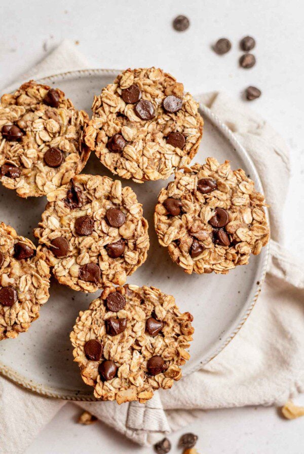 6 baked banana chocolate chip oatmeal cups on a grey plate.