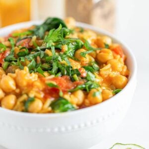 A bowl of chickpea rice stew topped with fresh cilantro.
