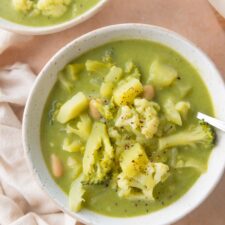 Bowl of soup with broccoli, cauliflower, white beans and potato.