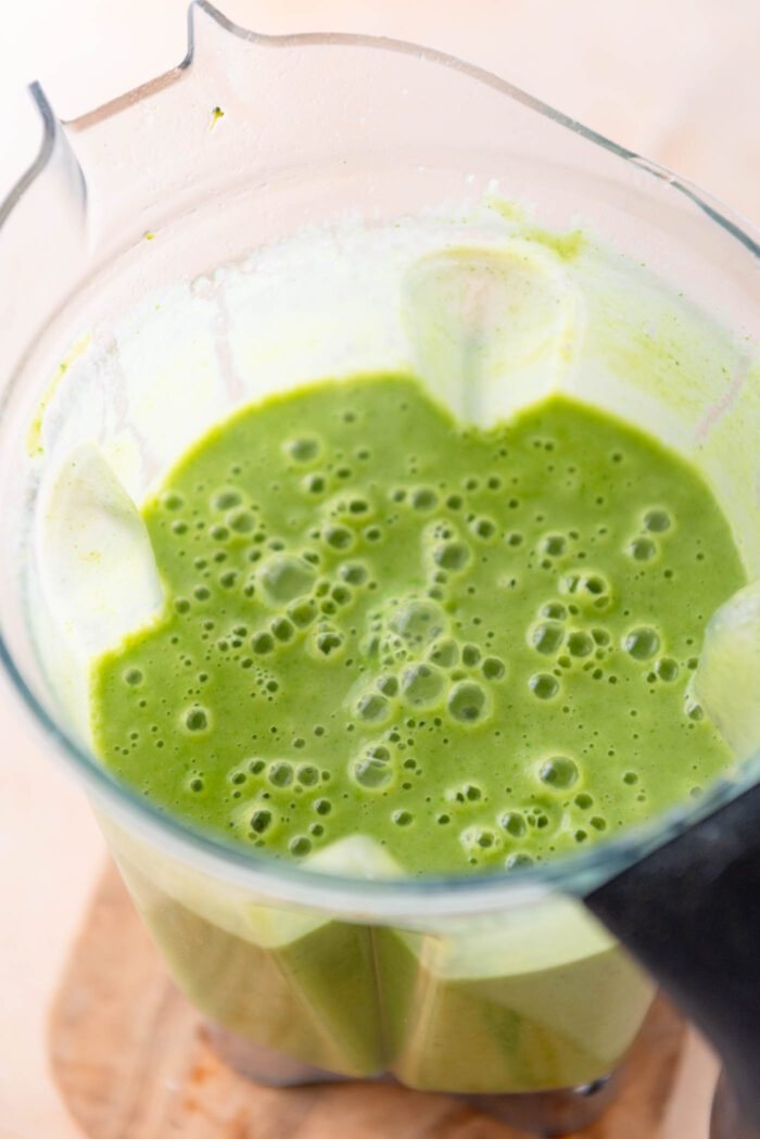 Green soup in a blender container.