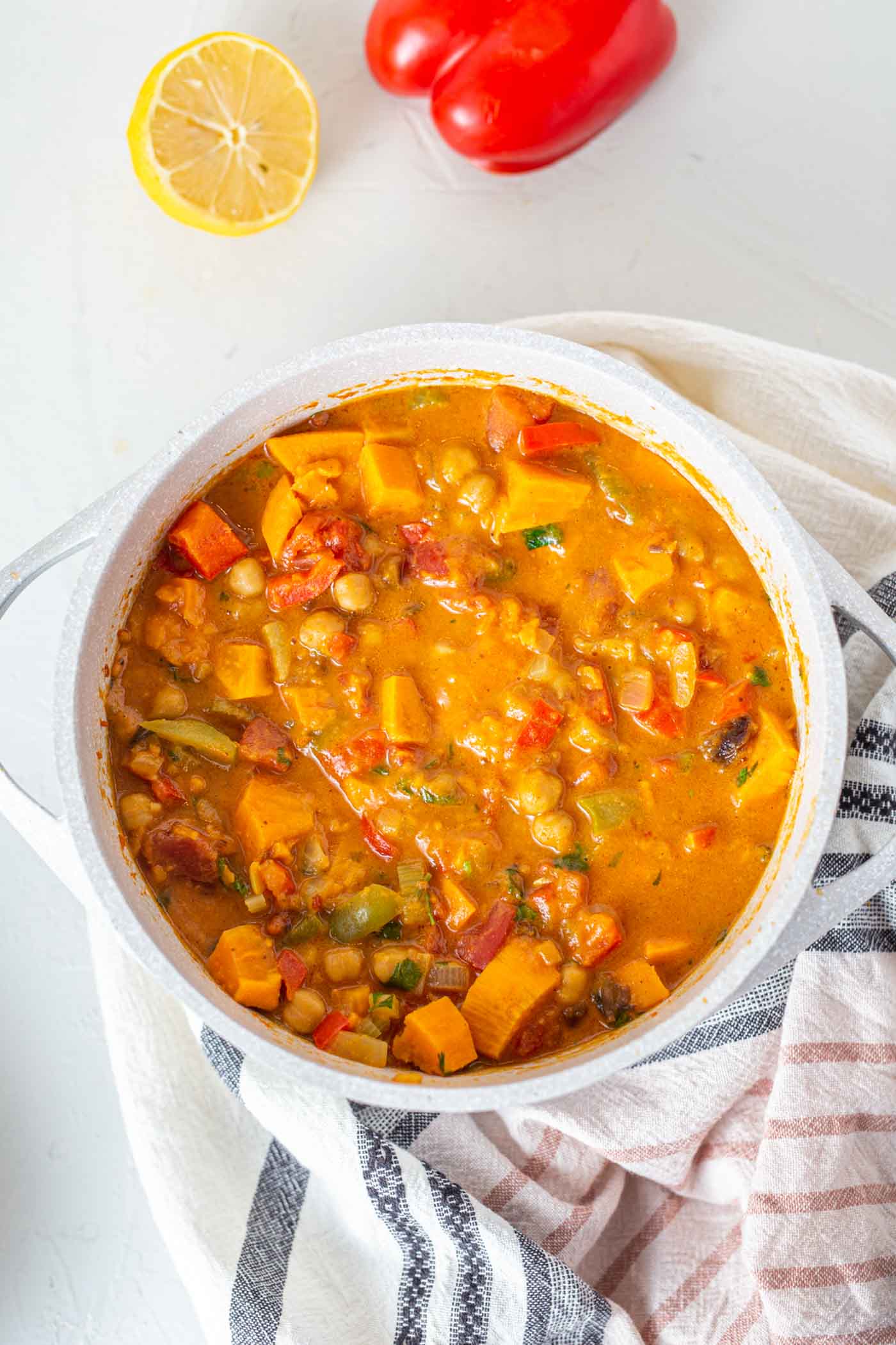 A large pot of sweet potato stew sitting on a dish towel.