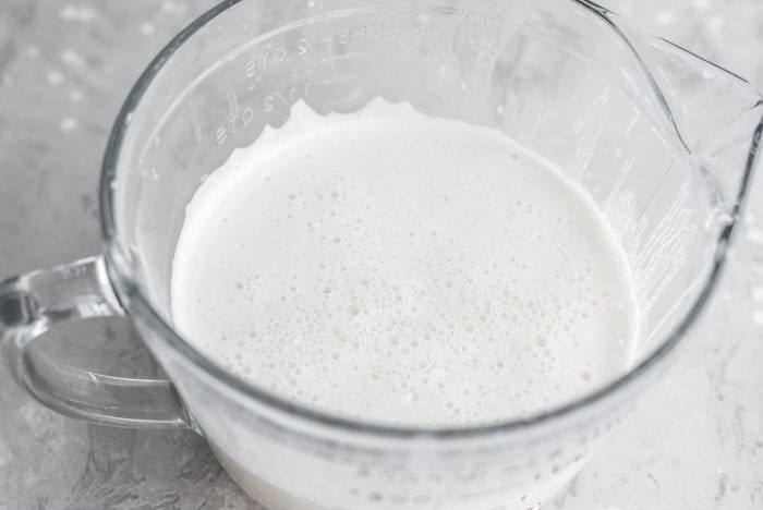 Strained homemade almond milk in a large glass measuring cup.