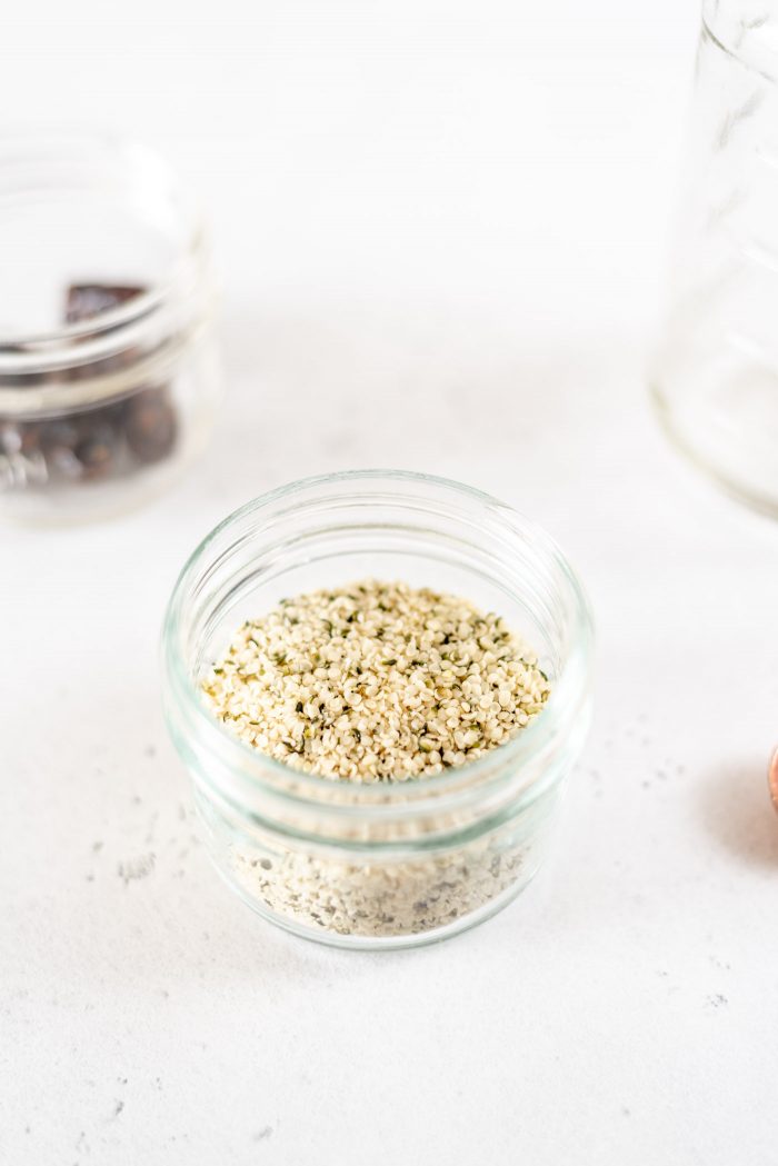 Small glass mason jar filled with hemp seeds.