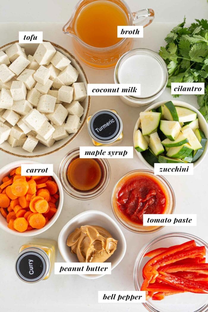 Labelled ingredients for a vegetable panang curry in bowls on a counter top.