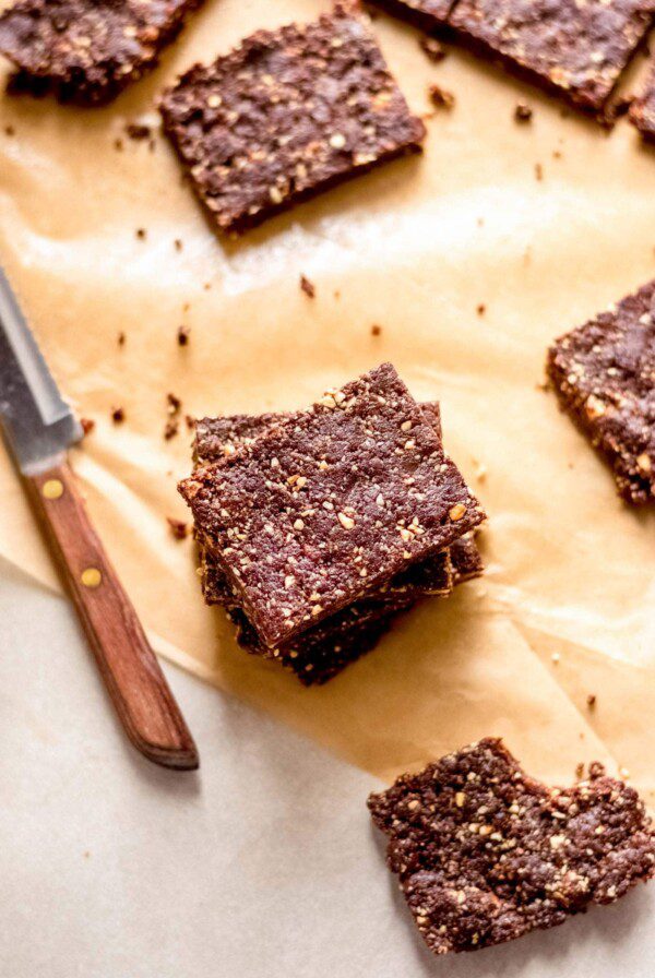 Overhead image of stack of chocolate brownies, a few scattered around.