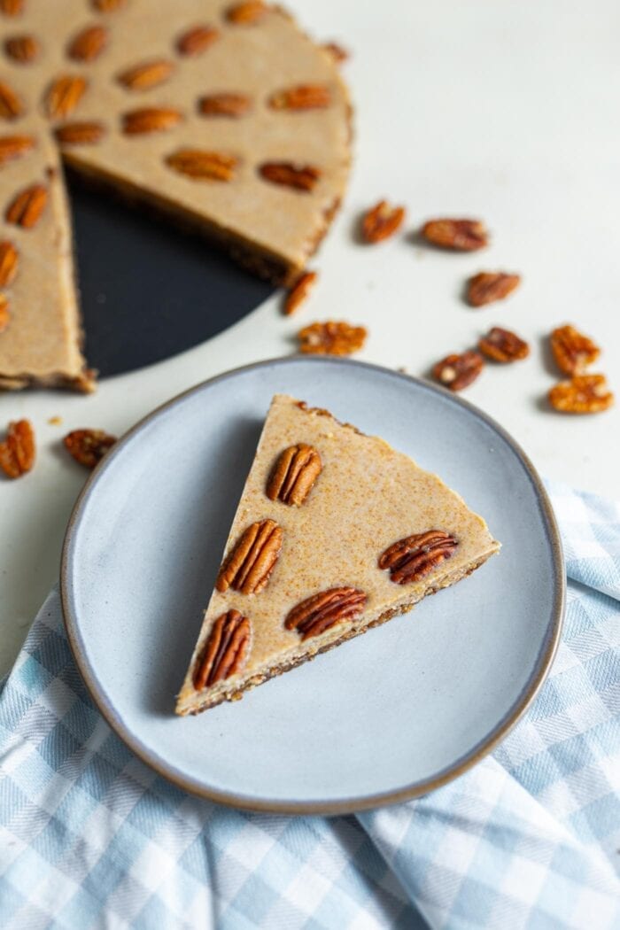 A slice of raw maple pecan pie on a small blue plate.
