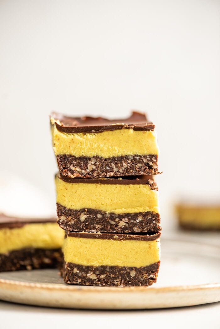 A stack of vegan Nanaimo bars on a small grey plate.