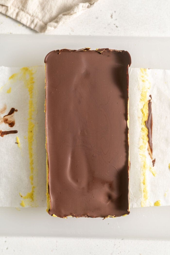 A block of homemade vegan Nanaimo bars on a cutting board.