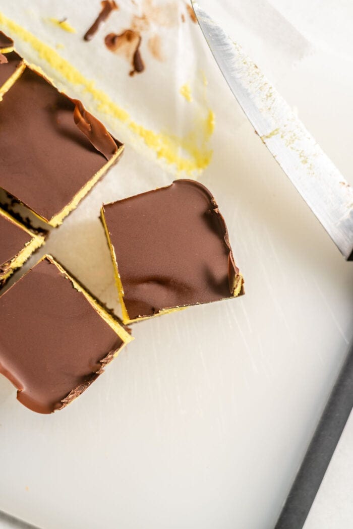 Sliced Nanaimo Bars on a cutting board.