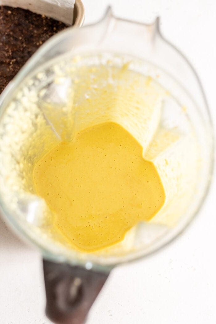 Creamy yellow custard filling for Nanaimo Bars in a blender.