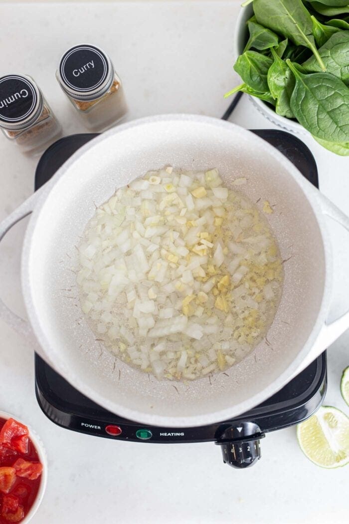Onions, garlic and ginger cooking in a pot.