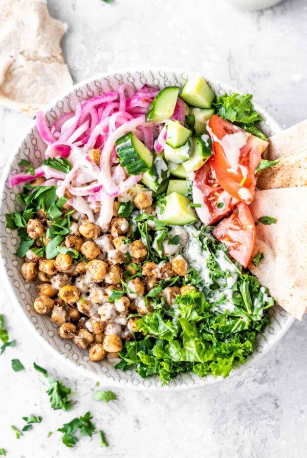 Salad with shawarma chickpeas, kale, parsley, pickled onions, pita and tomato.