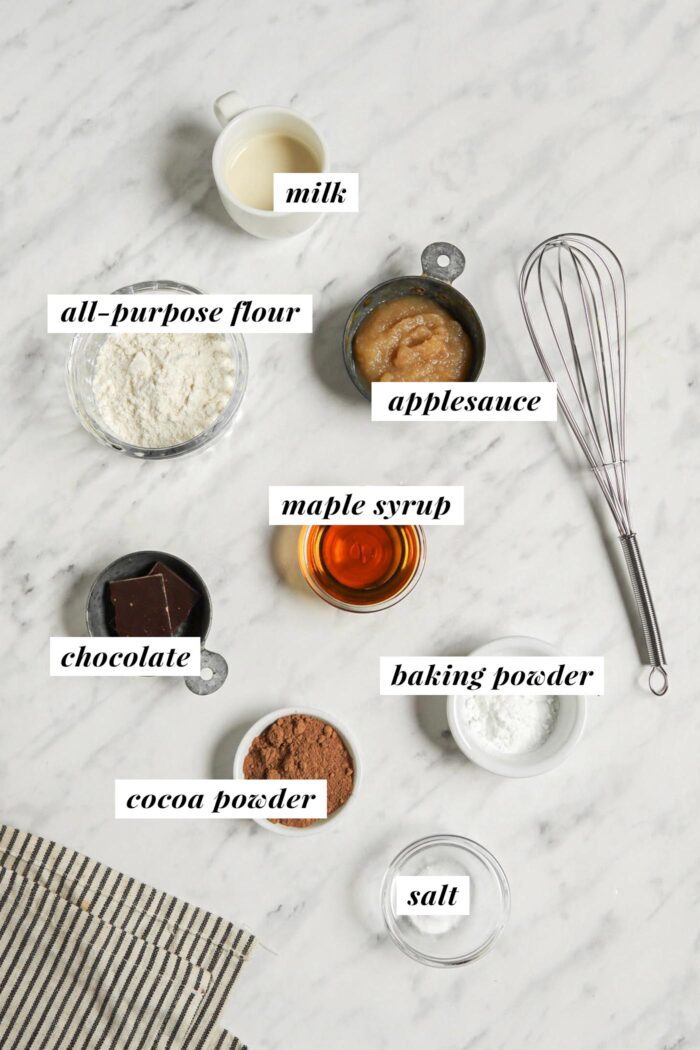 Visual list of ingredients for making a chocolate mug cake recipe. Each ingredient is labelled with text.
