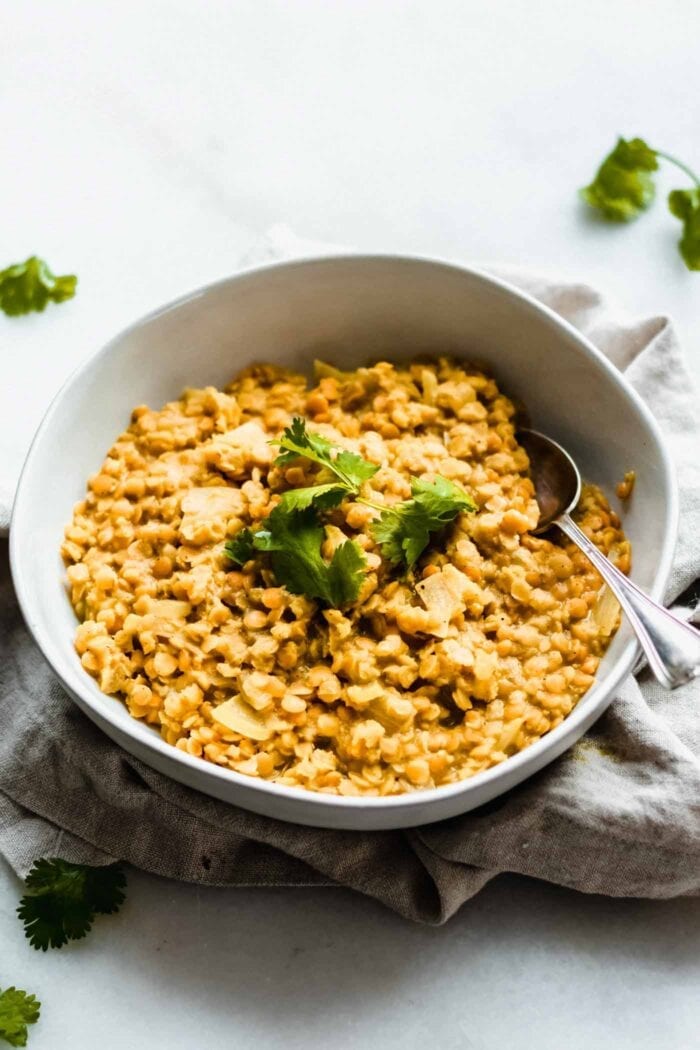 A bowl of red lentil dahl topped with fresh cilantro.
