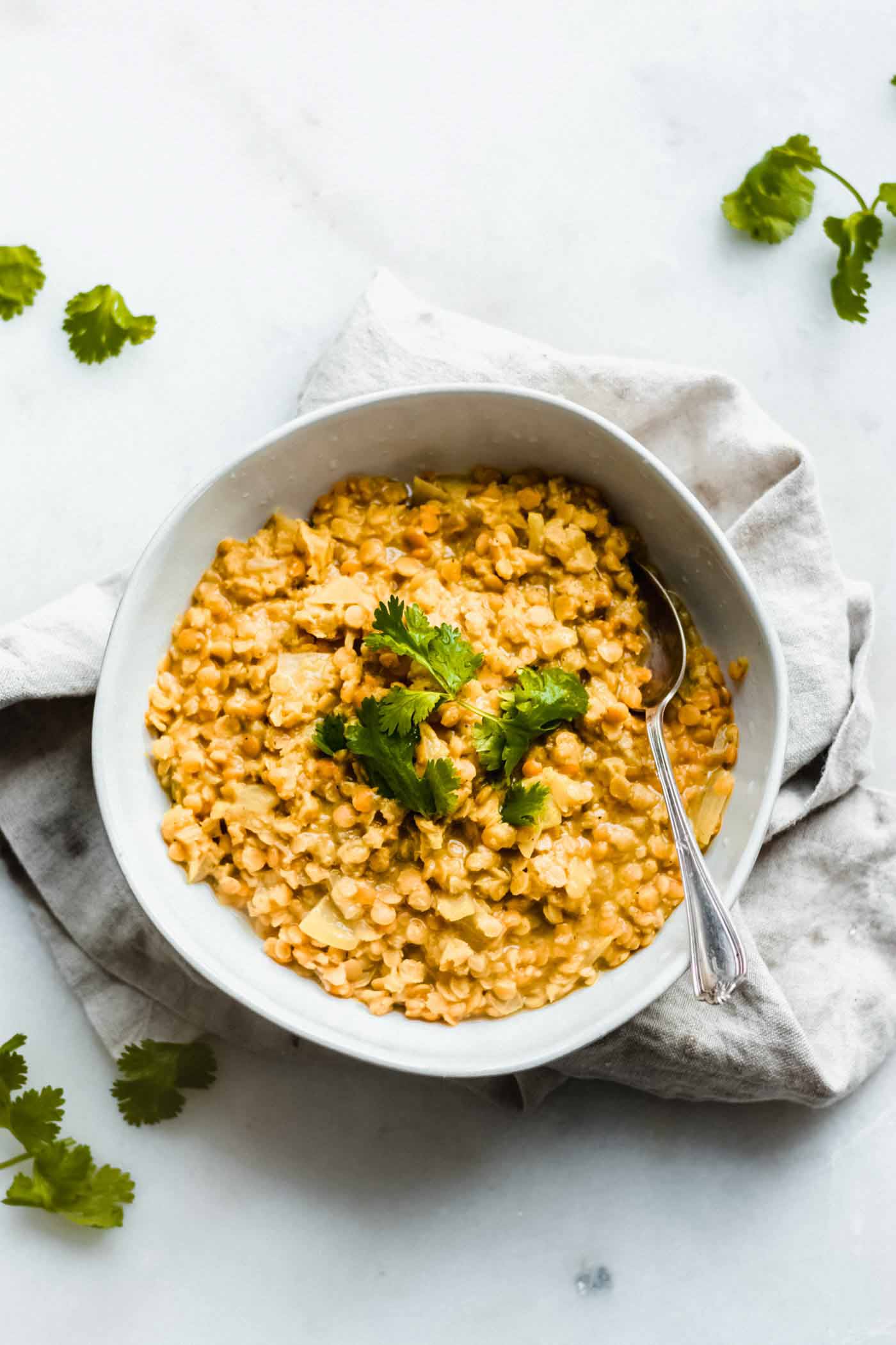 A bowl of red lentil dahl topped with fresh cilantro.