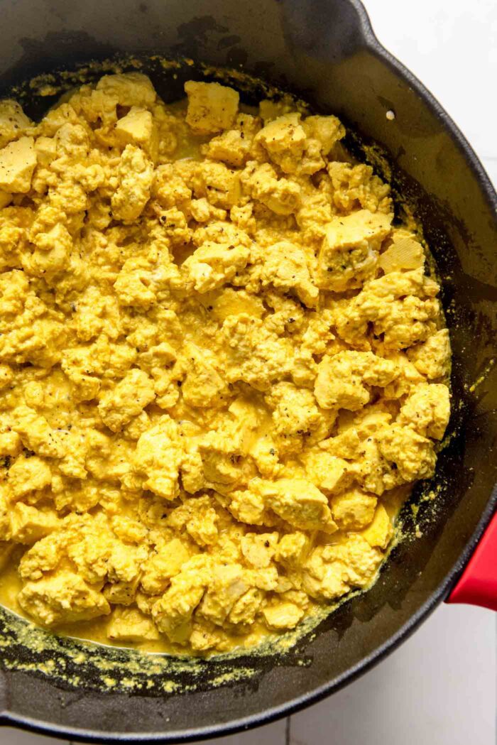 Tofu scramble cooking in a cast iron skillet.
