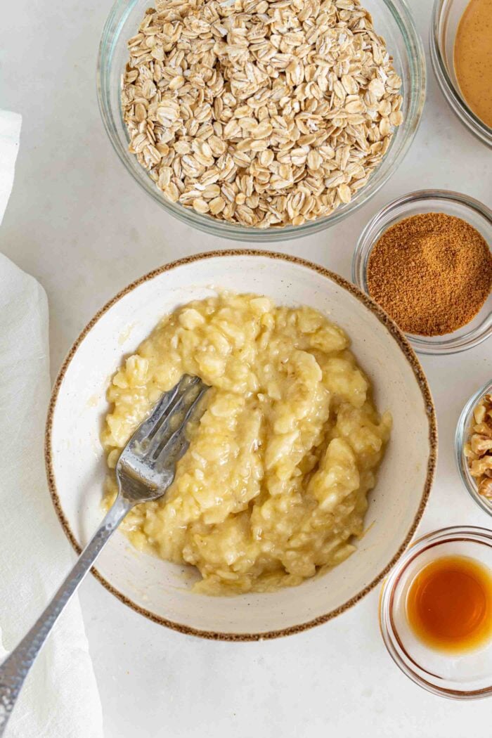 Mashed banana in a bowl with a fork.