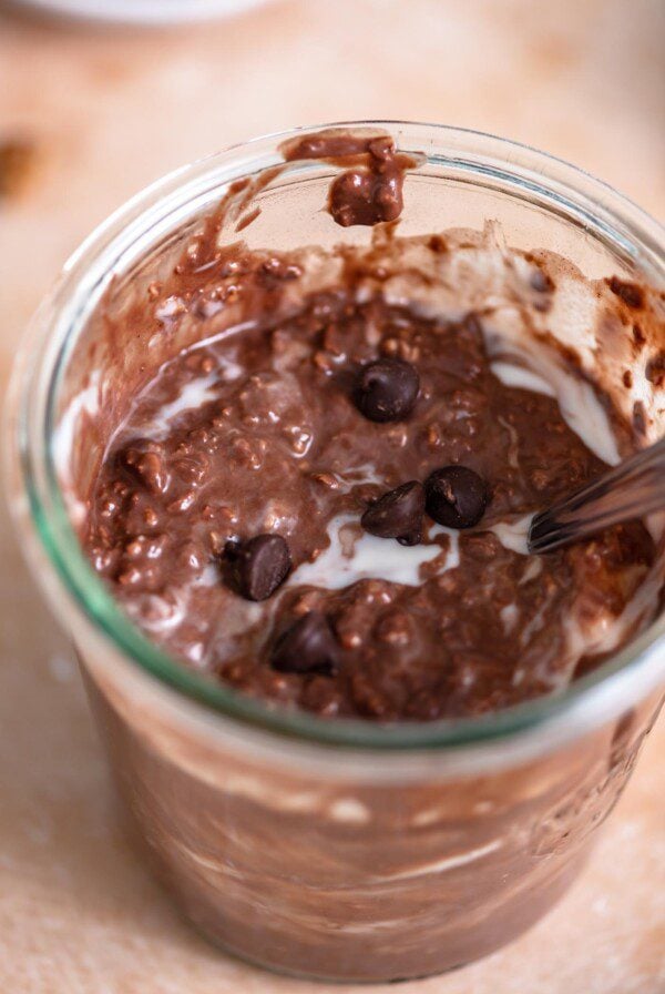 Jar of overnight chocolate protein oats with a few chocolate chips sprinkled over top.