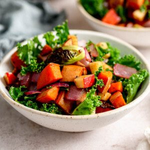 Roasted vegetable kale apple salad with sweet potato in a small bowl.