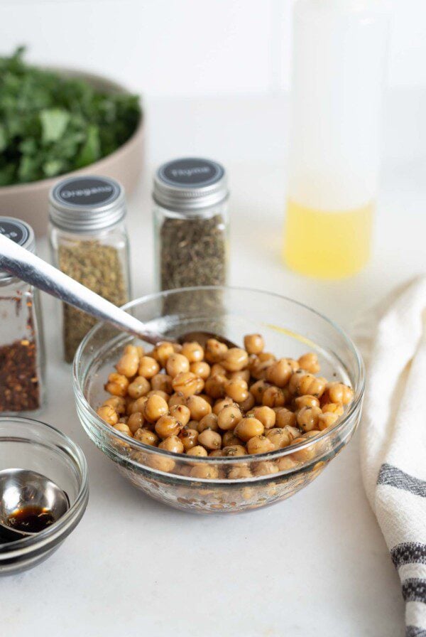 Chickpeas with balsamic vinegar and herbs in a small bowl with a spoon,