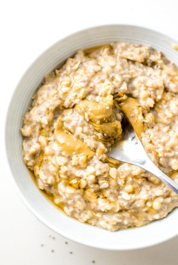 Bowl of banana oatmeal topped with peanut butter.