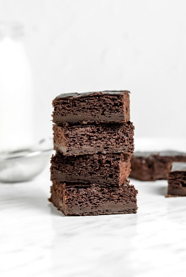 Front view of a stack of 4 sweet potato brownies sitting on a marble surface.