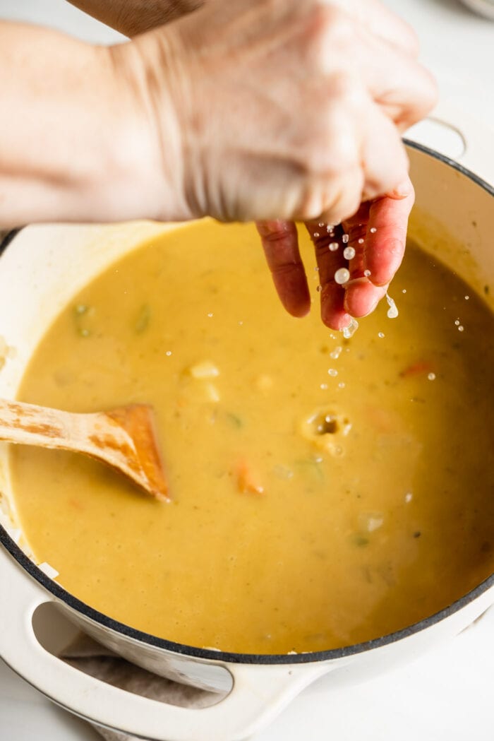 Squeezing fresh lemon juice into a pot of soup.