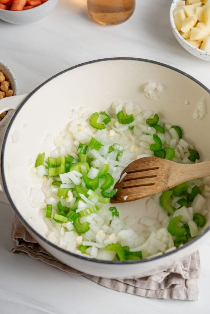 Celery, onion and garlic cooking in a soup pot.