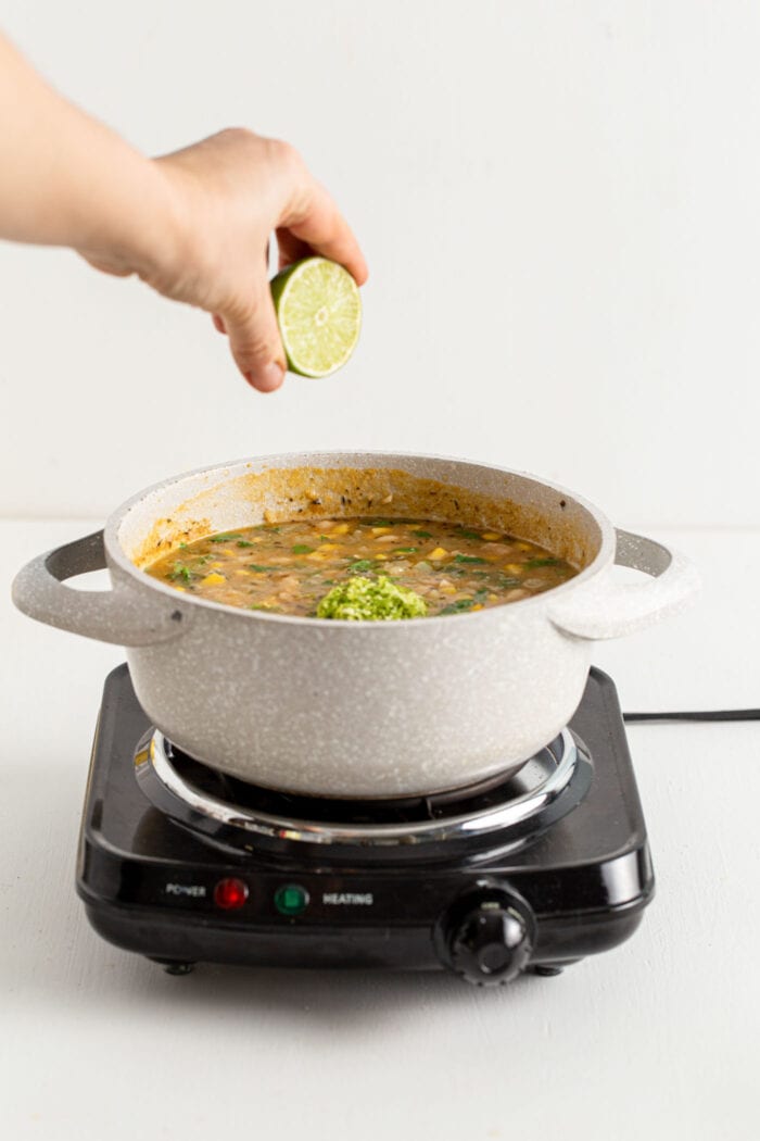 Squeezing lime into a pot of white bean chili.