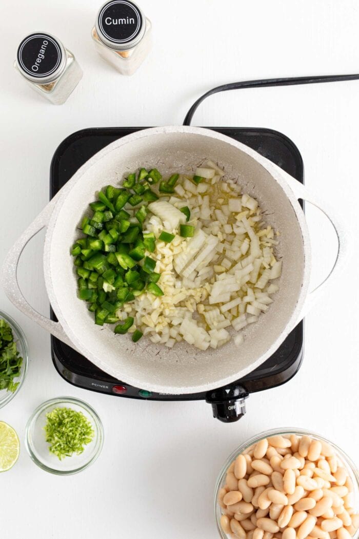 Jalapeno, garlic and onion cooking in a large soup pot.